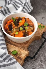 stewed vegetables in a bowl, lecho vegetarian, gray background