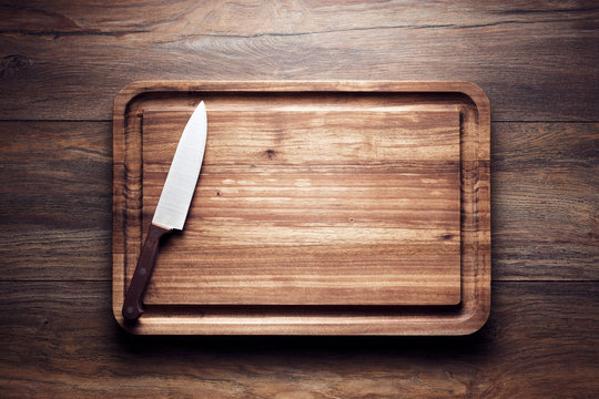 Vintage wooden cutting board with knife on wooden table