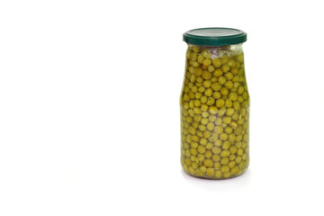 Canned green peas in a glass jar with a metal lid on a white background. Harvesting vegetables. Copy space left