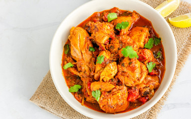 Indian Chicken Peshawari, Spicy Indian Style Chicken Curry Garnished with Lemon and Cilantro, Top Down Flat Lay Indian Food Photo