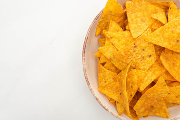 top view of corn nachos in bowl on white background