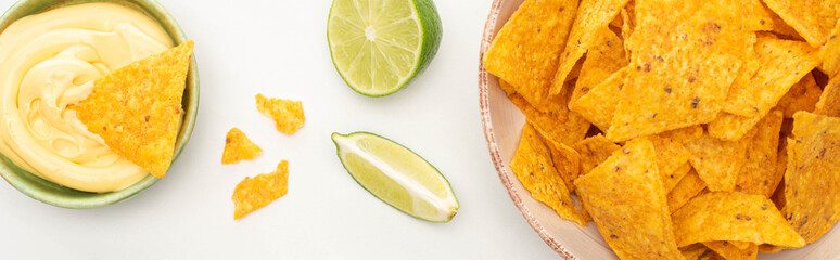 top view of corn nachos with lime and cheese sauce on white background, panoramic shot