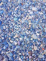 Multi-colored pebbles on the seashore, background
