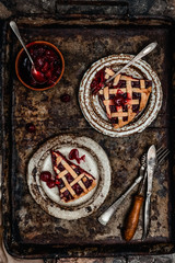 Flat-lay of cherry pie cut in slices over brown concrete background, top view. traditional seasonal dessert