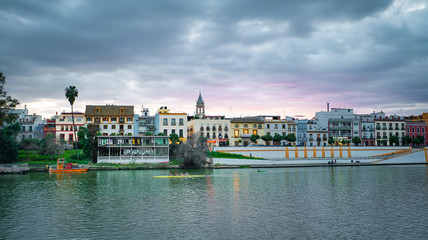 Seville, Spain - February 15th, 2020 - the River Guadalquivir bank near the Triana bridge in Seville, Spain.