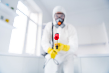 Blurred low angle view photo of sprayer cleaner hold latex gloves goggles coverall spray sanitize...