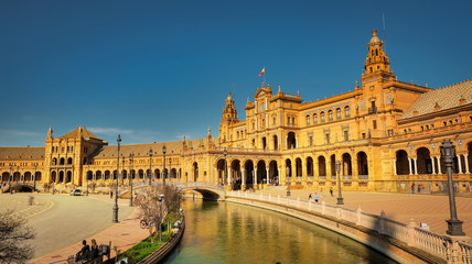 Obraz premium Seville, Spain - February 16th, 2020 - Plaza de Espana / Spain Square with the Canal and beautiful architecture details in Seville City, Spain.