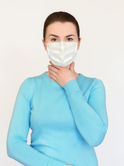 a woman in a blue sweater and medical mask clutched her throat. The concept of the fight against the virus, infection, fear