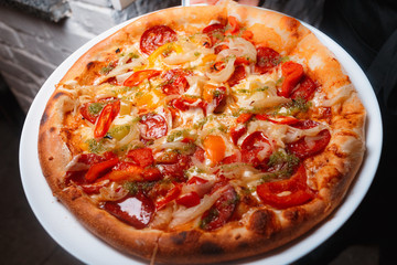 Tasty Italian pizza with cheese, pepperoni, arugula, cocktail tomatoes and  grilled bell pepper