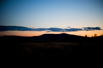 Evening landscape at sunset, warm sunlight over the field, Urals, September