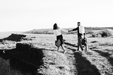 A guy and a girl love each other, smile, hug, kiss, laugh, enjoy life in the forest on a cliff, in...