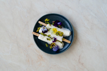 Homemade Indian Rajasthani Kulfi Ice Cream with Stick / Kesariya with Pistachio and Edible Flowers