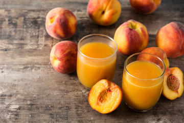 Natural peach juice in glass on wooden table	