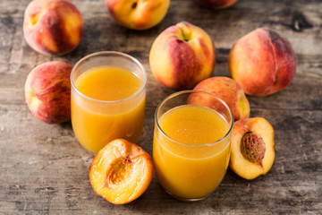 Natural peach juice in glass on wooden table	