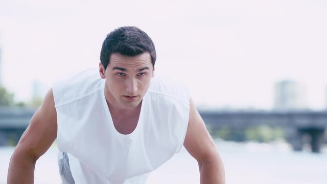 young, handsome sportsman doing push ups outside