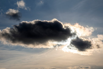 Obraz premium A rain cloud, the sun hid behind a cloud.