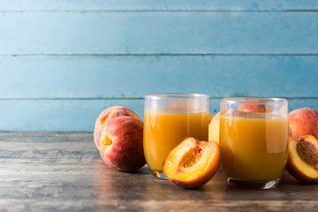 Natural peach juice in glass on wooden table	