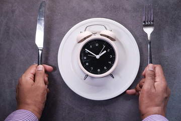 the concept of Healthy Food, alarm clock on plate 