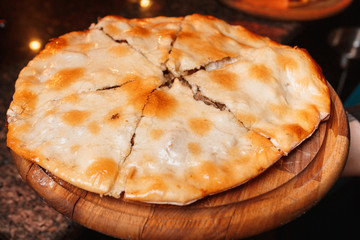 Georgian khachapuri  or kubdari with grilled veal meat filling served on wooden tray