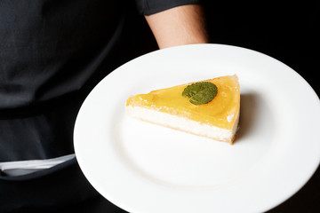 Classic cheesecake with yellow jelly topping served on white plate