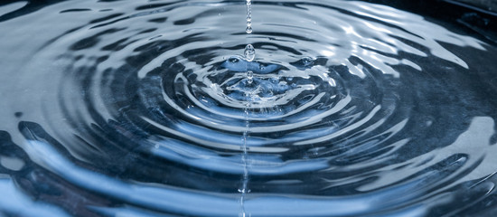 Fallende Wassertropfen auf Wasseroberfläche