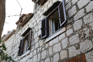 Fototapeta na wymiar Shuttered windows - Old houses with shuttered windows
