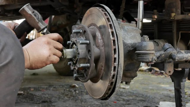 Technicians are removing the right front wheel hub of the car for replacement and repair.