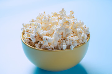 Popcorn in a cup is illuminated by a beautiful light.