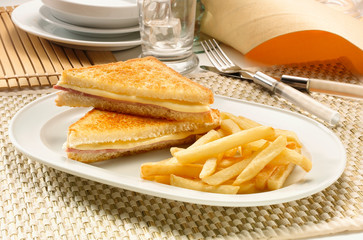 sandwich de jamón y queso con patatas fritas. ham and cheese sandwich with chips.
