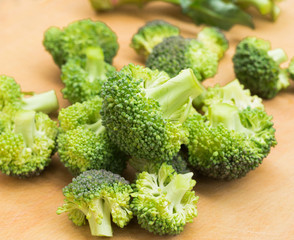 resh appetizing broccoli inflorescences on wooden board