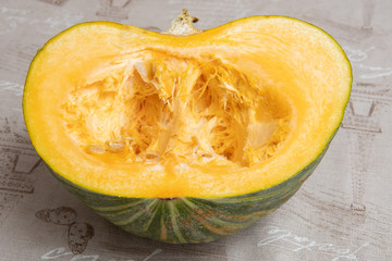 Green pumpkin, juicy fresh and ripe cut in half on the kitchen table. The concept of a healthy diet, vegetarianism