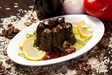 Olive oil stuffed leaves on the plate with vegetable for service for restaurant concept from Turkey.