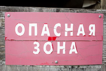 Old warning sign "Danger zone" in Cyrillic Russian detailed close up