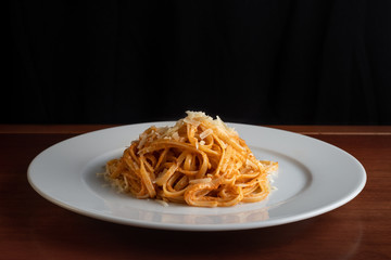 Spaghetti with red pesto and parmesan cheese.