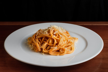 Spaghetti with red pesto and parmesan cheese.
