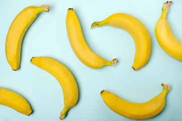 Top view of whole bananas on the blue surface as a decorative background