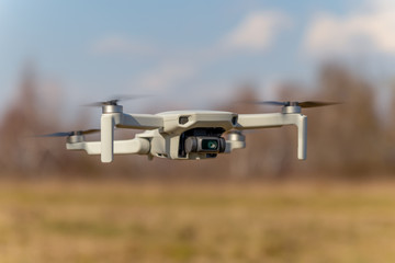 Small drone in flight on blue sky background