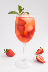 Cocktail drink with strawberry and ice in a glass on the white  background. Location vertical. Closeup.