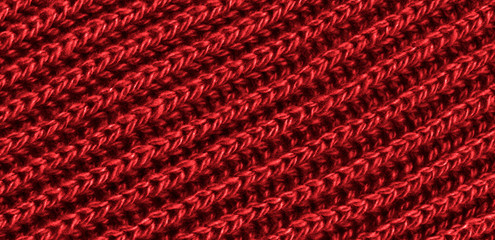 Bright red texture knitted wool scarf. Red textile background knitwear. Close-up