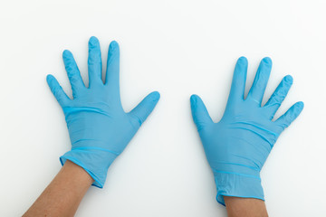 Hands in blue latex gloves on white table