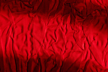 Bright red texture of binding crumpled fabric. Red textile background with natural folds. Close-up