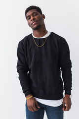 Street fashion concept - Studio shot of young handsome African man wearing sweatshirt against white...