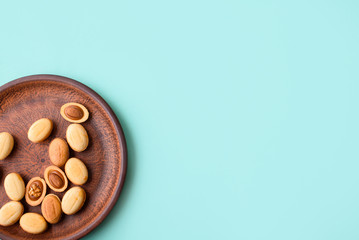 Homemade nuts with condensed milk, chocolate inside, walnuts and almonds. Dessert to tea on a plate on a light blue background.