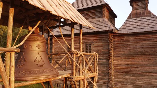 Steel metal church bell campane. Old wooden rustic village orthodox church.