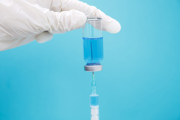 Fototapeta premium The doctor collects medicine from an ampoule into a syringe. Covid 19