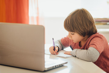 Distance learning online education. Schoolboy studying online watching his lesson on laptop. Studying home
