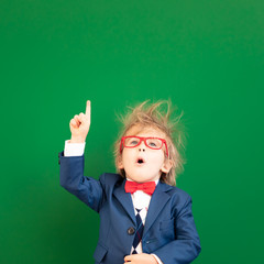 Bright idea! Happy child student against green chalkboard