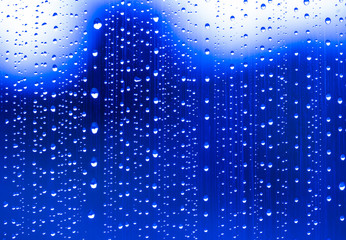 Fototapeta na wymiar blue rain water drops on a window glass close up , colored drop background macro in a blue light