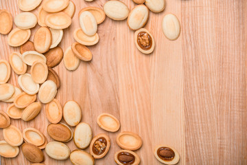 Homemade Russian nuts with condensed milk on a light pink background, wafer napkin. Cut nuts with condensed milk. Bitten goodies for coffee. Condensed Nuts. Flat lay
