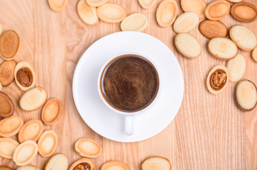 Homemade Russian nuts with condensed milk on a light pink background, wafer napkin. Cut nuts with condensed milk. Bitten goodies for coffee. Condensed Nuts. Flat lay